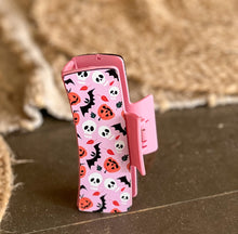 Pink Halloween Hair Claw with friendly bats, pumpkins, and skulls on a pastel pink background – handmade in the Outer Banks